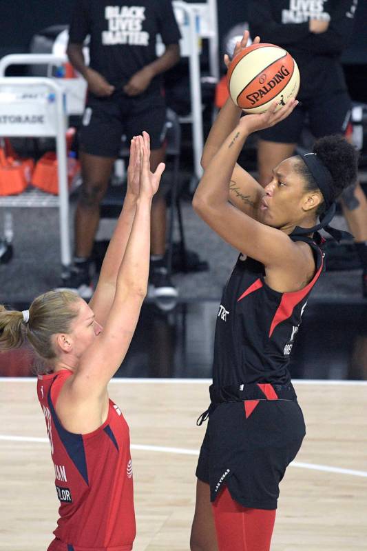 Las Vegas Aces center A'ja Wilson, right, goes up for a shot in front of Washington Mystics gua ...