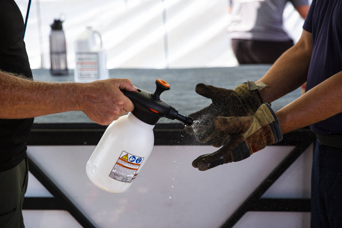 Todd Shelton, operations manager at the Firefighter Combat Challenge, sanitizes the gloves of f ...