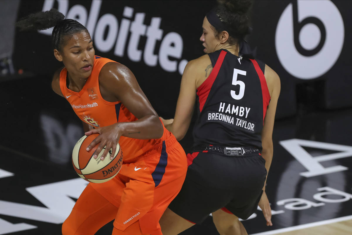 Connecticut Sun's Alyssa Thomas, left, avoids the defense of Las Vegas Aces' Dearica Hamby duri ...