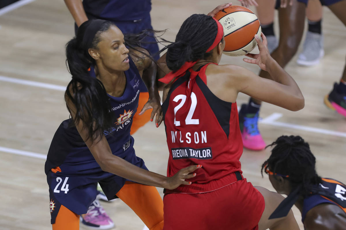 Las Vegas Aces' A'ja Wilson (22) drives against Connecticut Sun's DeWanna Bonner (24) during th ...
