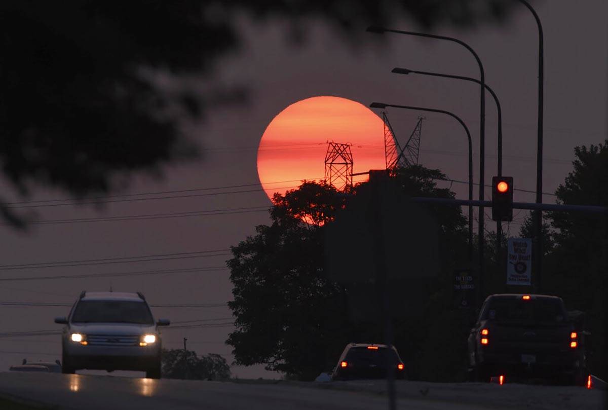Traffic flows on Townline Road as a hazy sun sets in Vernon Hills, Ill,, Tuesday, Sept. 15, 202 ...