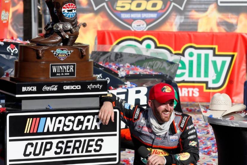 Austin Dillon smiles as he takes a knee in Victory Lane to catch his breath after winning a NAS ...