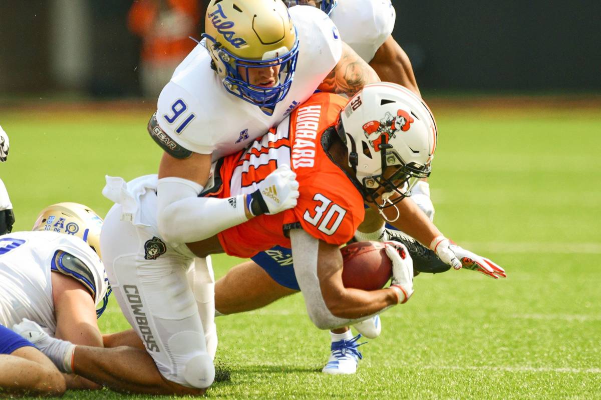 Tulsa defensive end Bryce Alonso (91) tackles Oklahoma State running back Chuba Hubbard (30) du ...