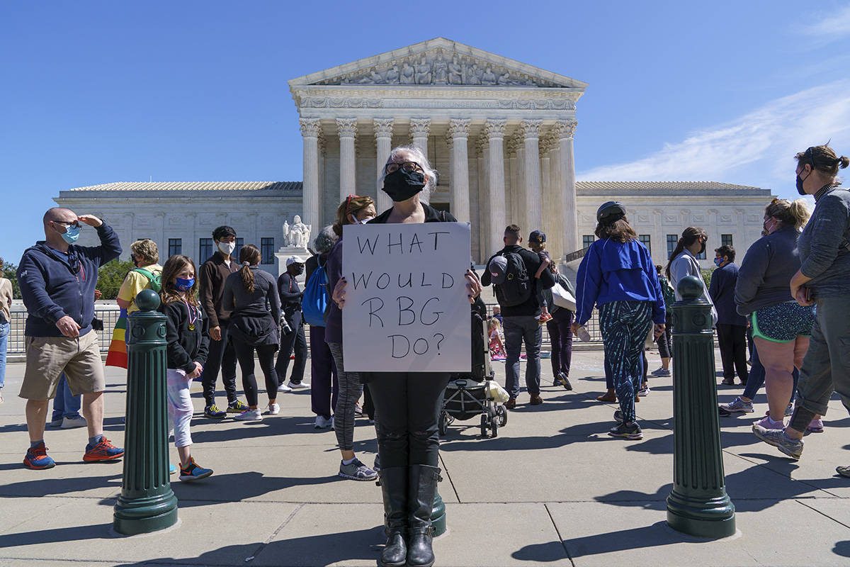 Kelli Midgley, center, an English teacher from Baltimore, joins people gathered at the Supreme ...