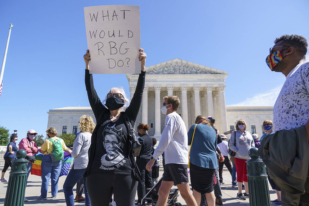Kelli Midgley, center, an English teacher from Baltimore, joins people gathered at the Supreme ...