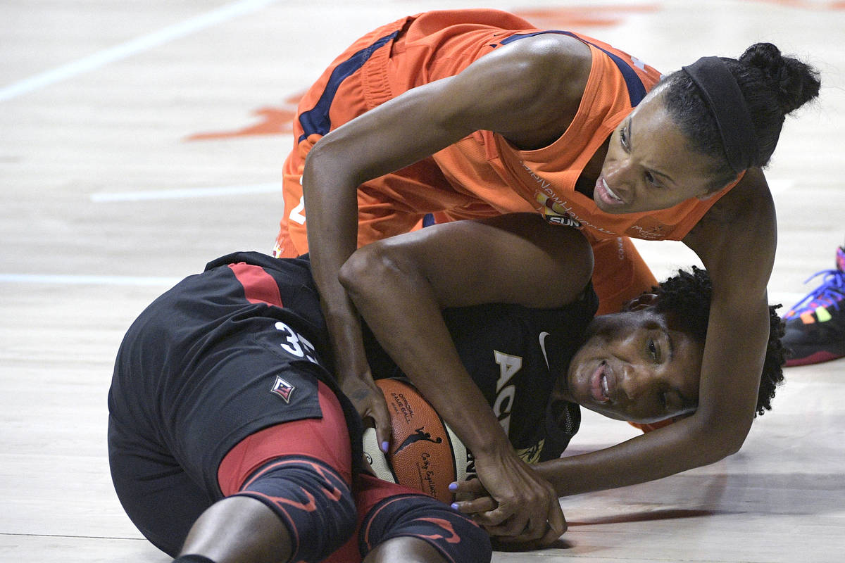 Connecticut Sun forward DeWanna Bonner, right, ties up Las Vegas Aces forward Angel McCoughtry, ...