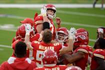 Kansas City Chiefs kicker Harrison Butker, top, is lifted by teammates after making the game-wi ...