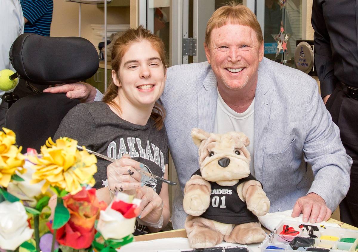 Las Vegas Raiders owner Mark Davis is shown with Opportunity Village client Sarah Brown during ...