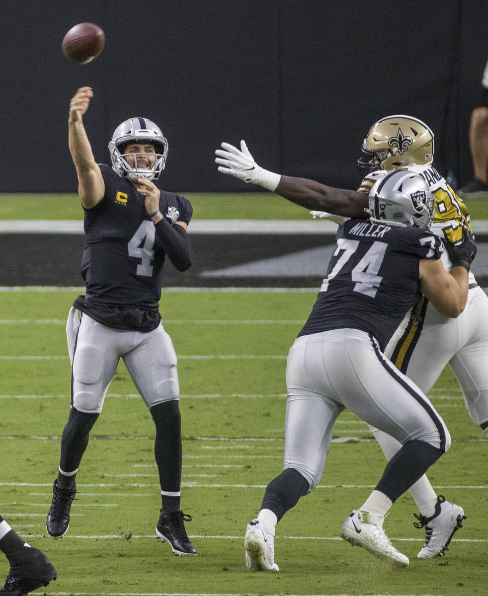 Las Vegas Raiders quarterback Derek Carr (4) gets off another pass with help from offensive tac ...
