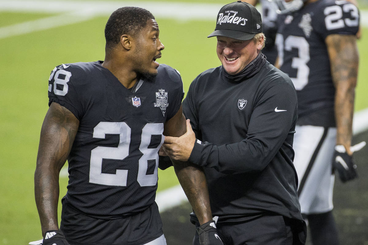 Las Vegas Raiders running back Josh Jacobs (28, left) jokes around with head coach Jon Gruden d ...