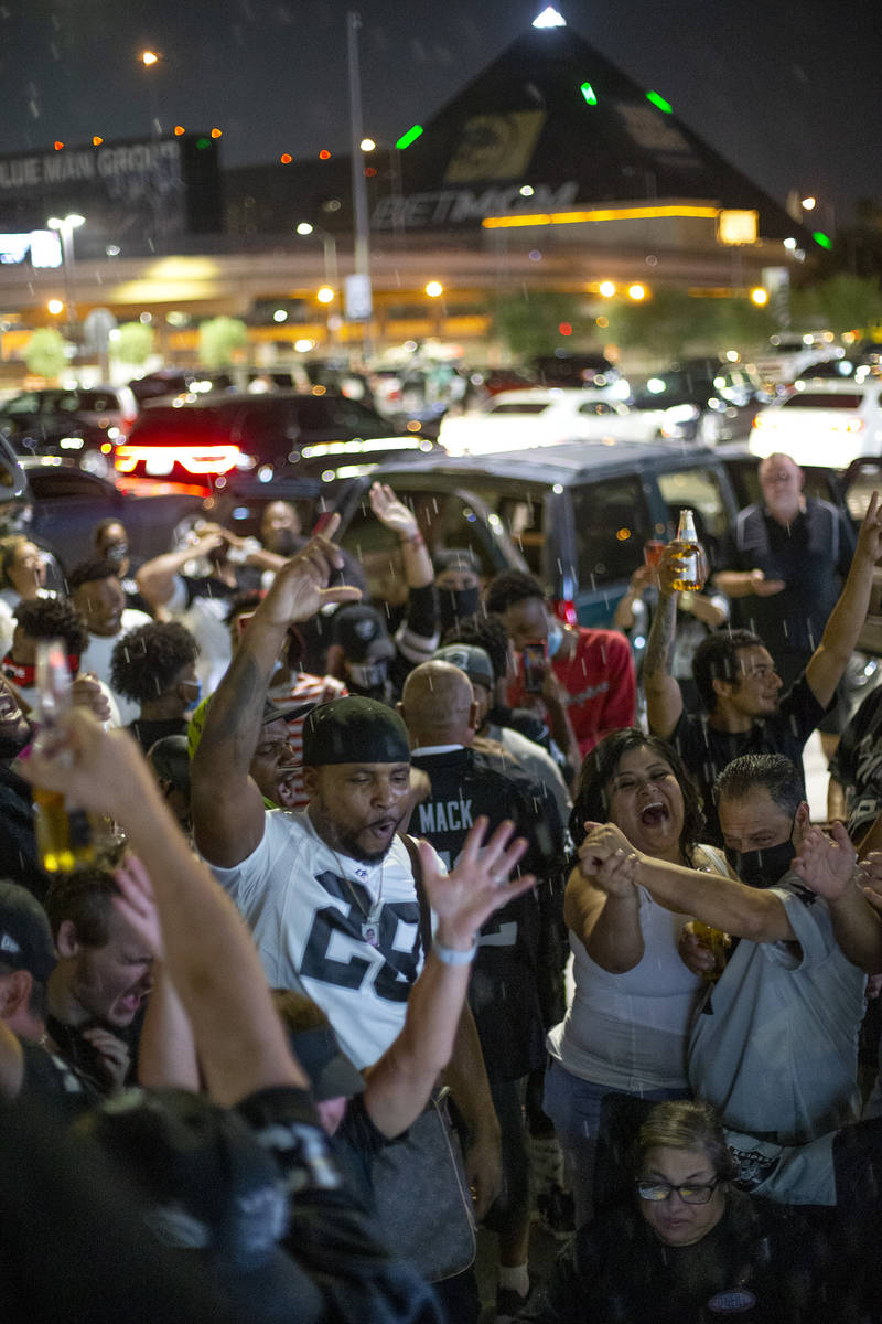 Raiders fans celebrate a Raider touchdown outside Allegiant Stadium on Monday, Sept. 21, 2020, ...