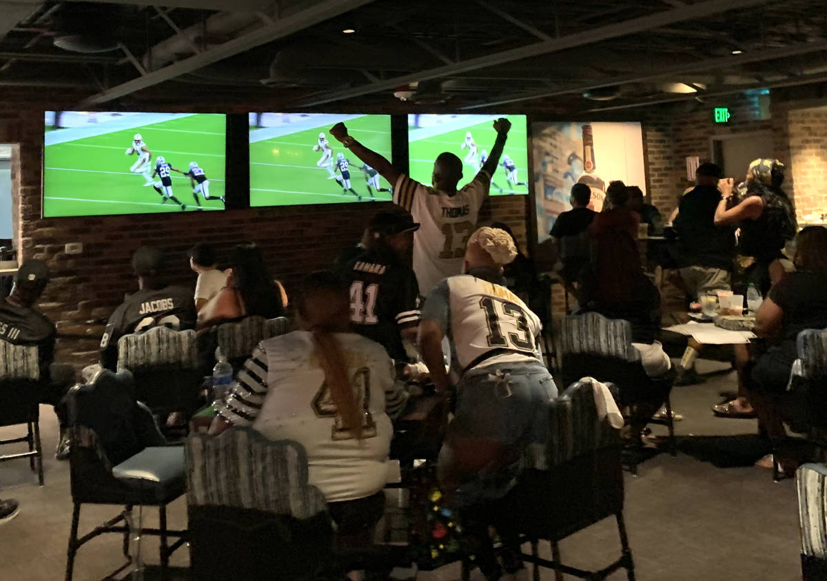 Saints fans applaud during a game at Whiskey Licker Up at Binion's on the Fremont Street Experi ...