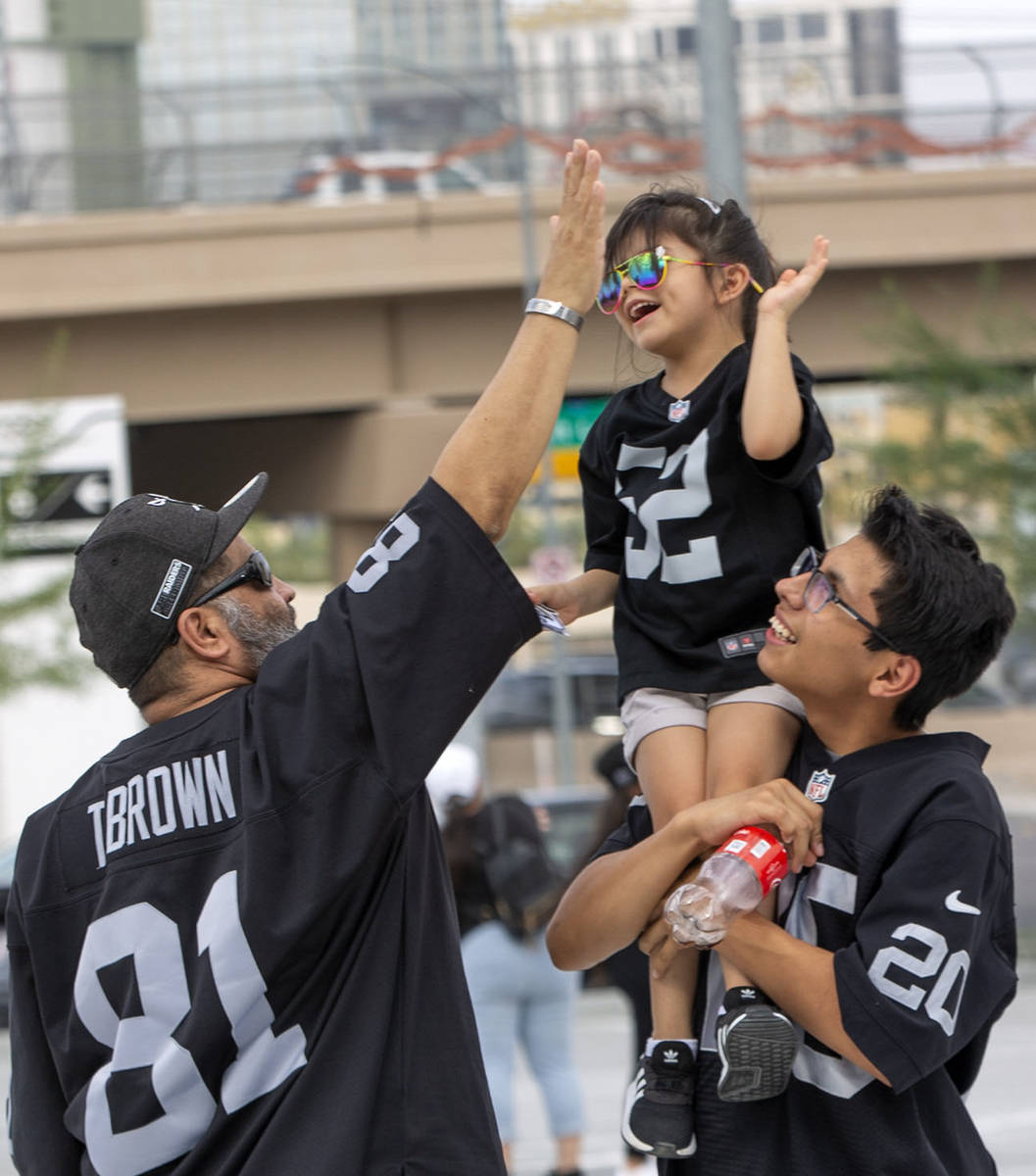 Mario Salazar high-fives his daughter Madyson Salazar, 5, who is carried by his son, Mario Sala ...