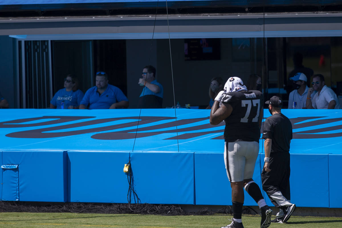 Las Vegas Raiders offensive tackle Trent Brown (77) walks off the field with a trainer after th ...
