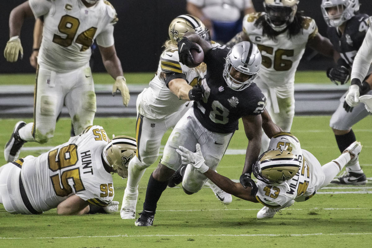 Las Vegas Raiders running back Josh Jacobs (28) breaks free from New Orleans Saints defensive e ...