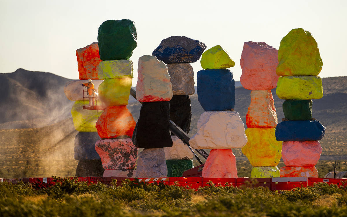 Ivan Ibarra with Vergith Contracting Co. prepares the Seven Magic Mountains for new paint by pr ...