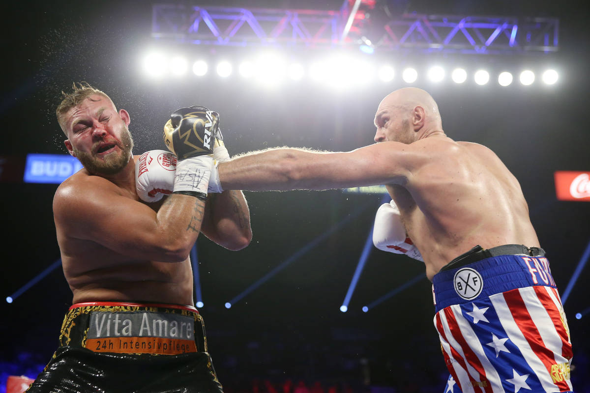 Tyson Fury, right, connects a punch against Tom Schwarz in the second round of the lineal heavy ...
