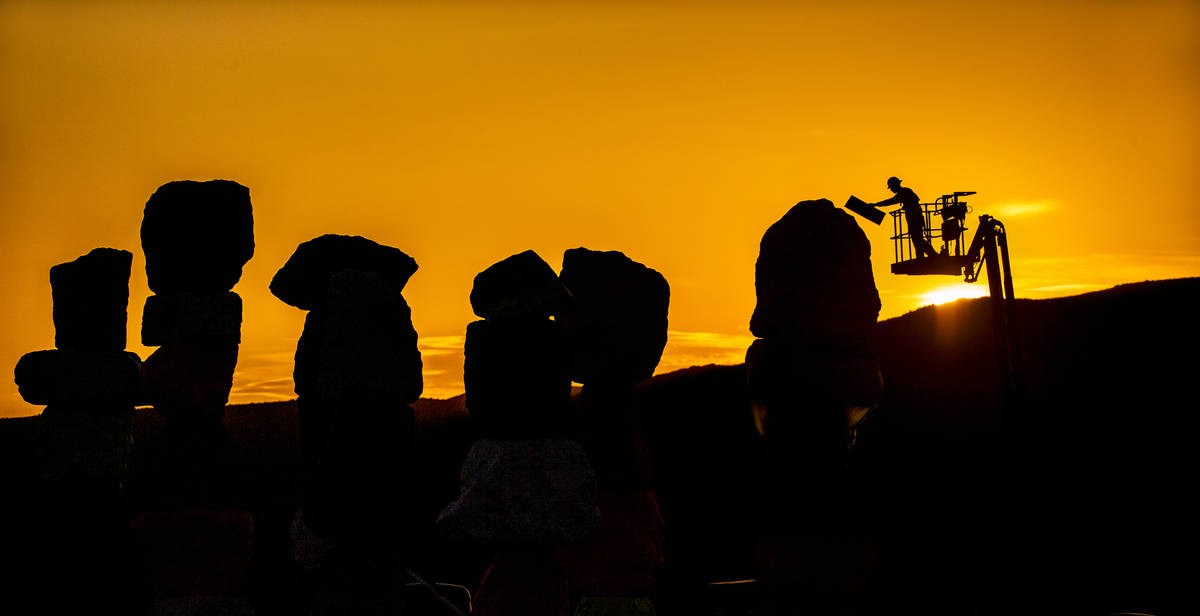 John Henderson works during sunrise on the final day of restoration on June 18. Ugo Rondinone s ...