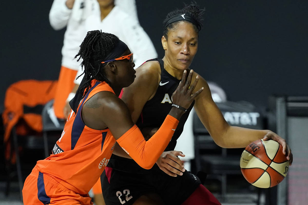 Las Vegas Aces center A'ja Wilson (22) drives around Connecticut Sun guard Essence Carson (17) ...