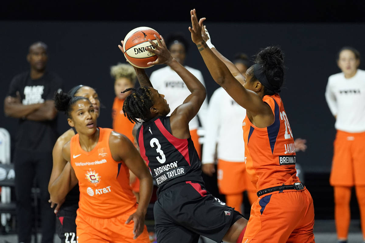 Las Vegas Aces guard Danielle Robinson (3) shoots between Connecticut Sun forward Alyssa Thomas ...