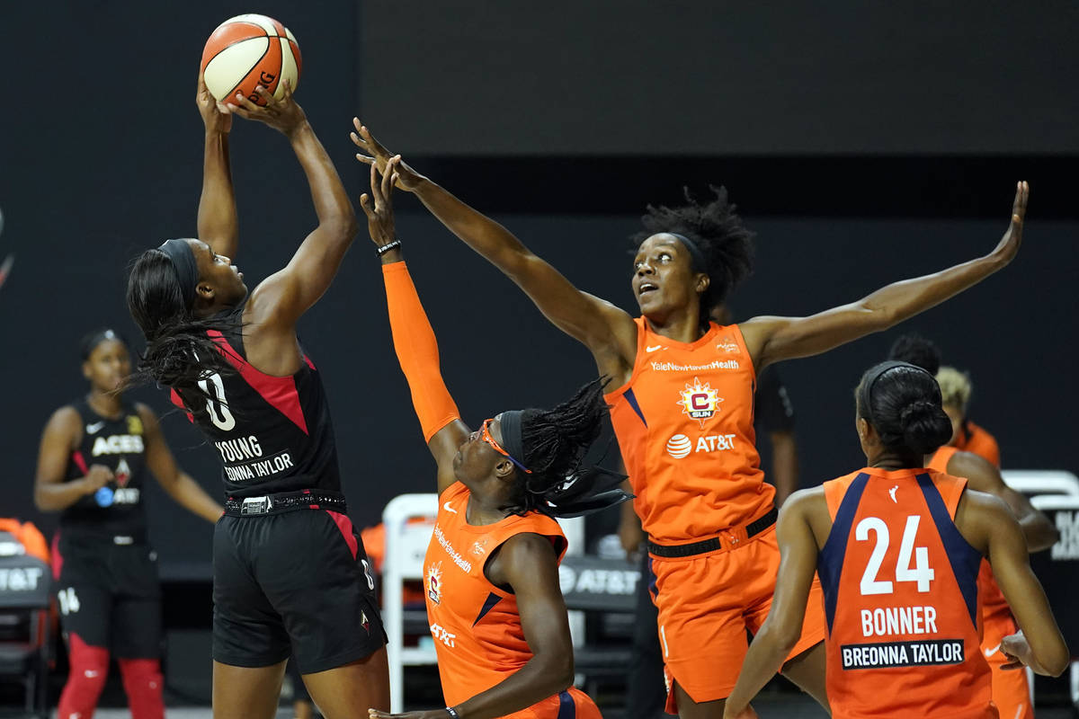 Las Vegas Aces guard Jackie Young (0) shoots over Connecticut Sun guard Essence Carson (17), fo ...