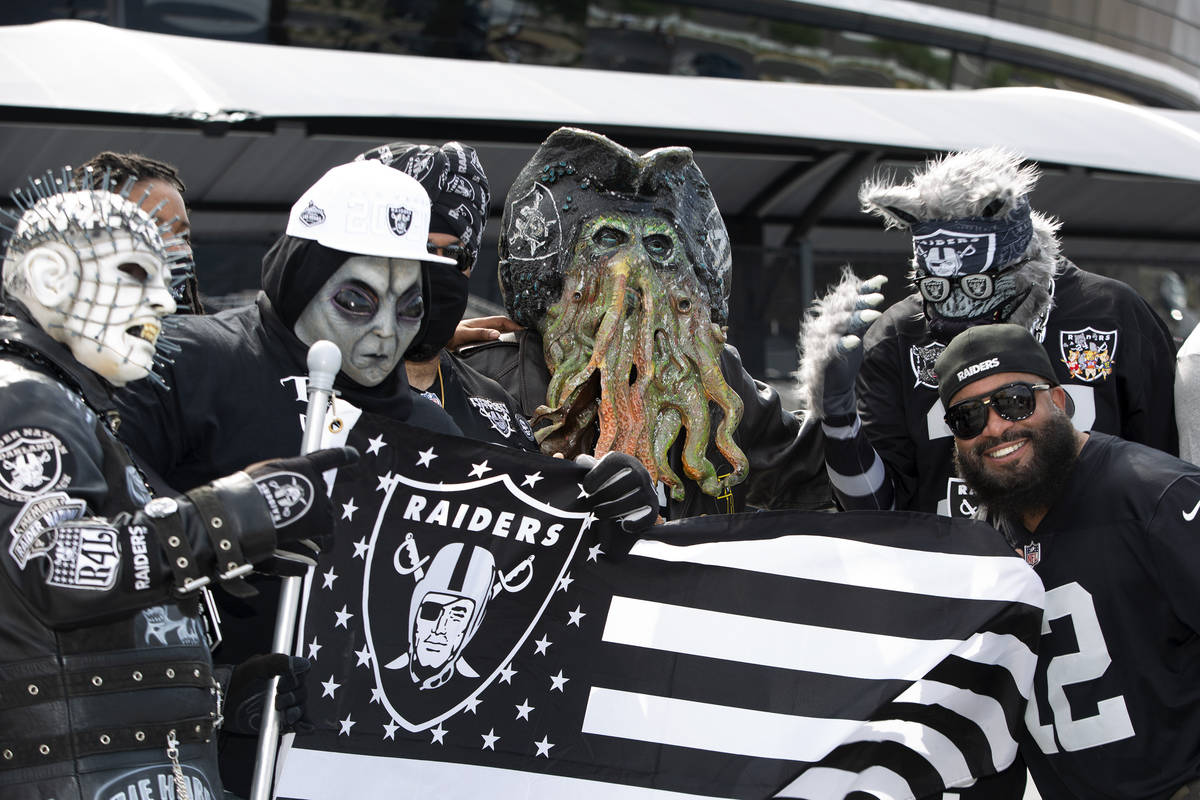 Patrick Beckett of New Jersey poses for a photo with Raiders fans in costumes as fans congregat ...