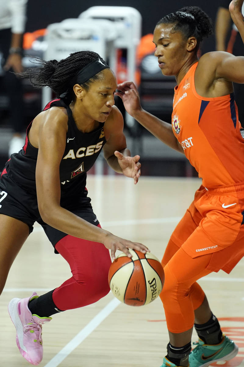 Las Vegas Aces center A'ja Wilson (22) drives against Connecticut Sun forward Alyssa Thomas (25 ...