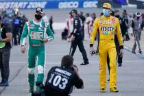Kevin Harvick, left, and Kyle Busch, right, walk to their cars prior to the start of a NASCAR C ...