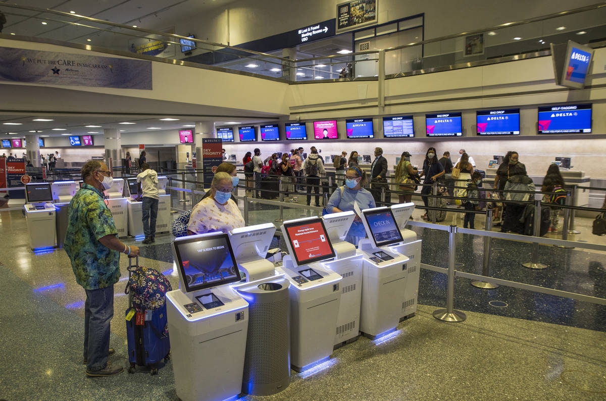 Delta Airlines customers check in machines as COVID-19 safety precautions continue at McCarran ...