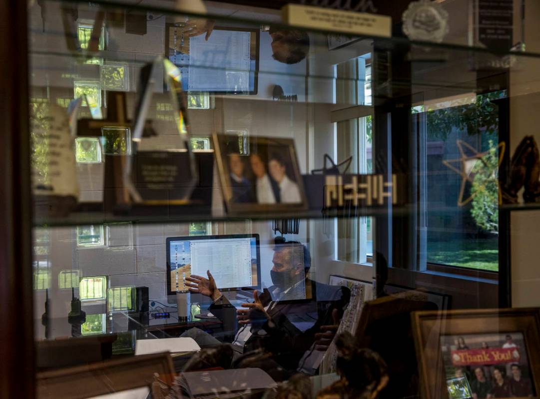 Dr. Steve Buuck, reflected in his awards case, serves as CEO of Faith Lutheran Middle School &a ...