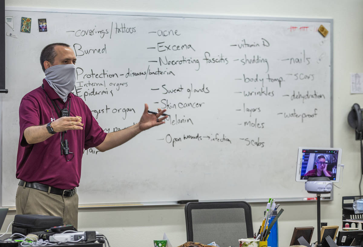 Teacher Steve Morrill stays socially distanced while teaching an anatomy and physiology class a ...