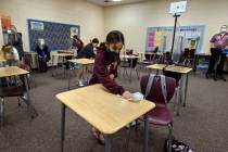 Student Alyssa Kazemi, 11, wipes down her desk with others in teacher Brandon Buskirk's 6th gra ...