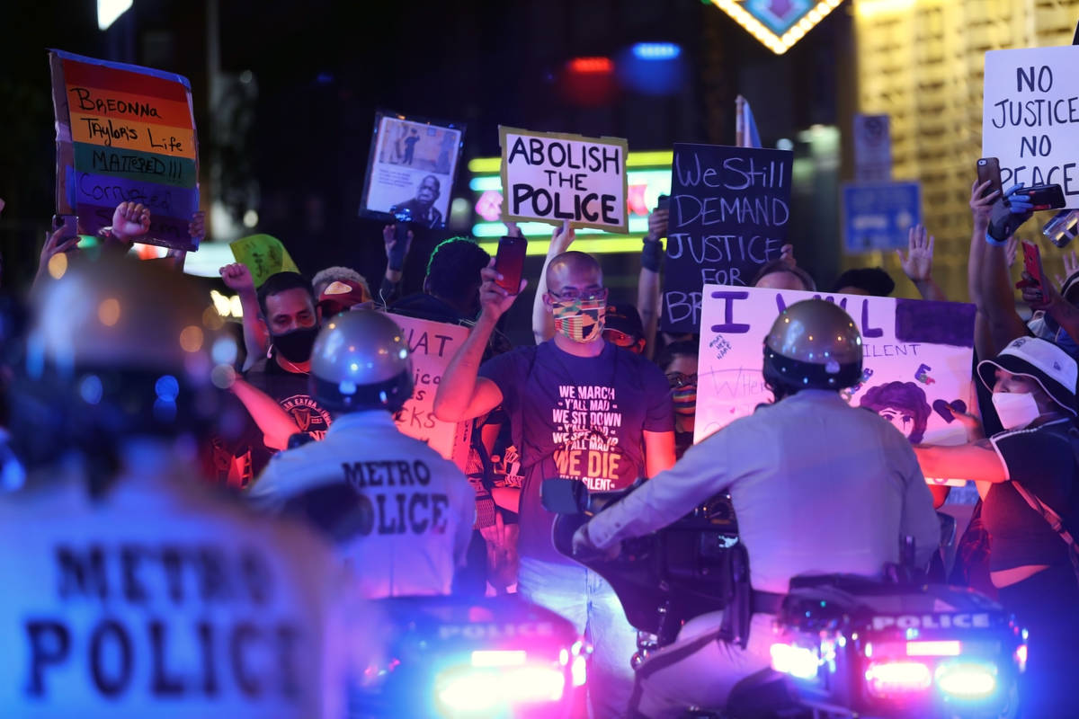 Protesters face law enforcement while standing in the middle of Las Vegas Blvd., in front of th ...