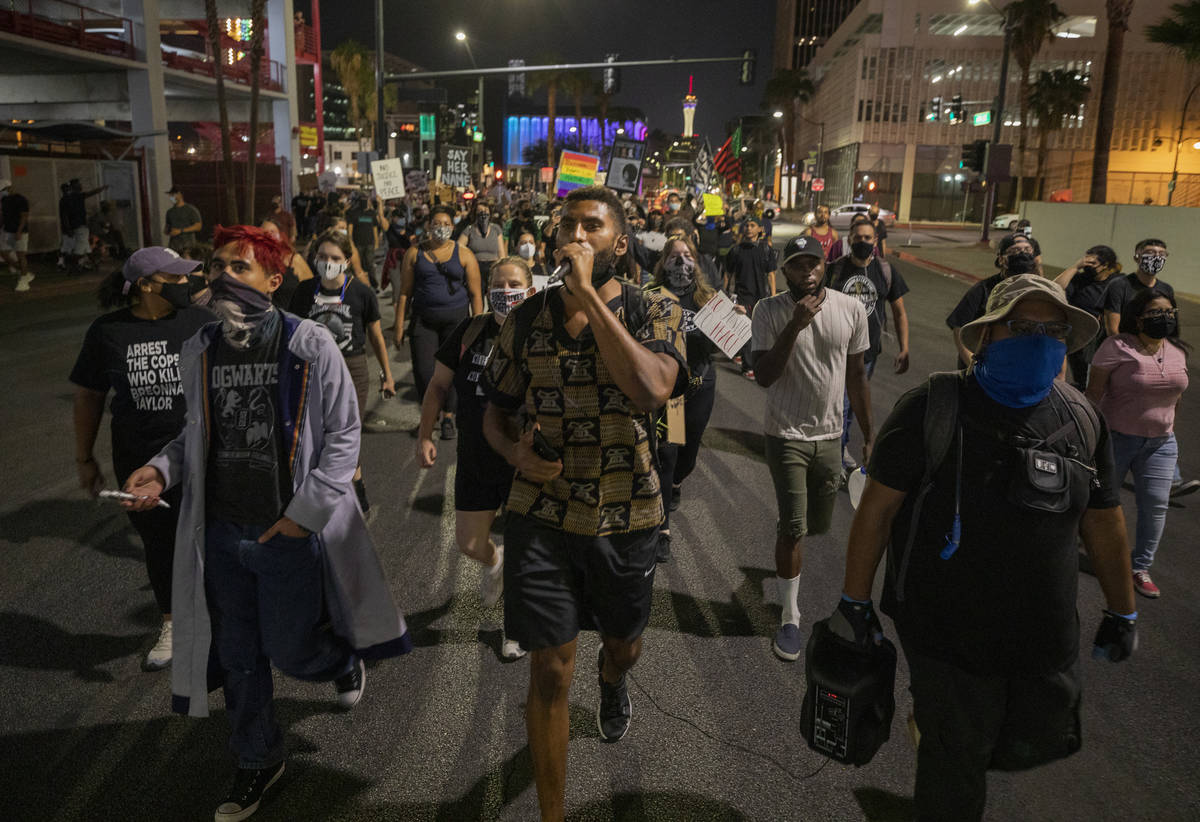 Protesters kneel in silence in honor of Breonna Taylor on Las Vegas Blvd., in front of the Frem ...