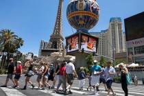 Tourists cross Las Vegas Boulevard near Paris hotel-casino on Friday, July 3, 2020, in Las Vega ...