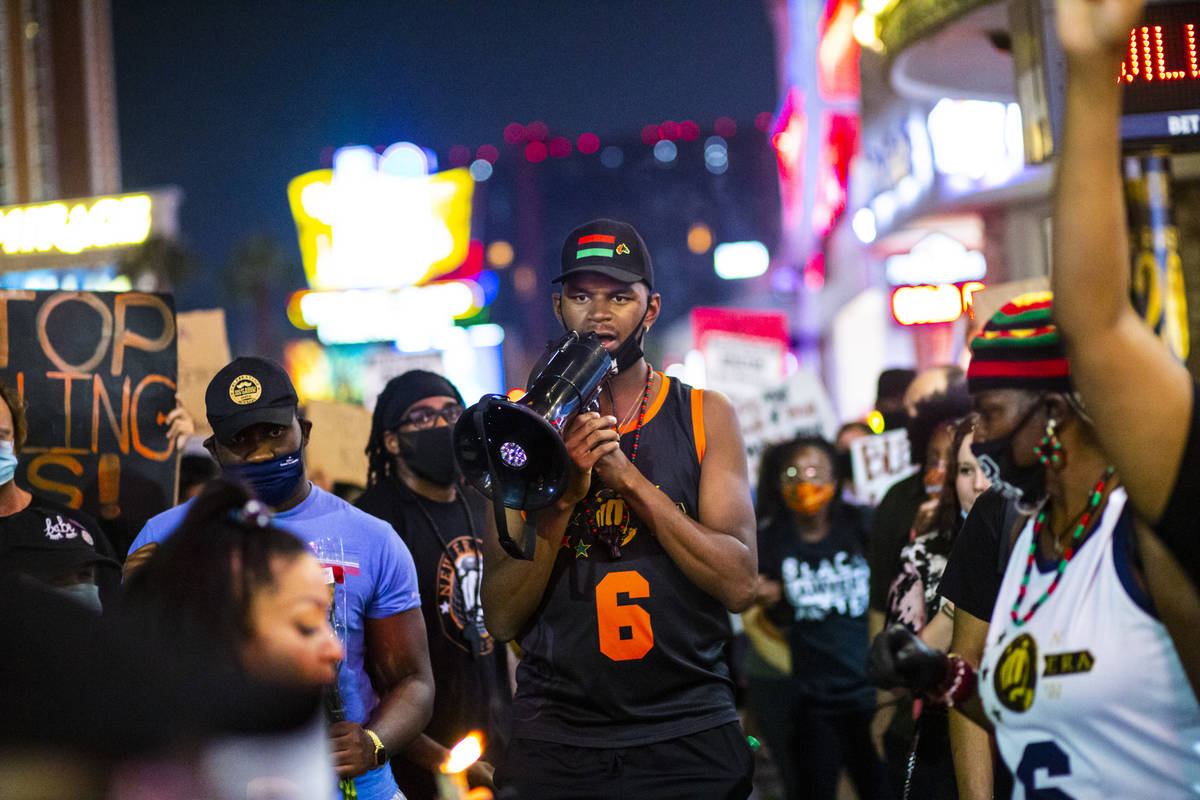 Minister Vance "Stretch" Sanders, right, addresses protesters as they march along the ...