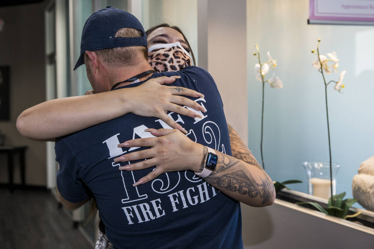 Seattle firefighter Dean McAuley, back, greets Natalia Baca whom he saved after a gunshot wound ...