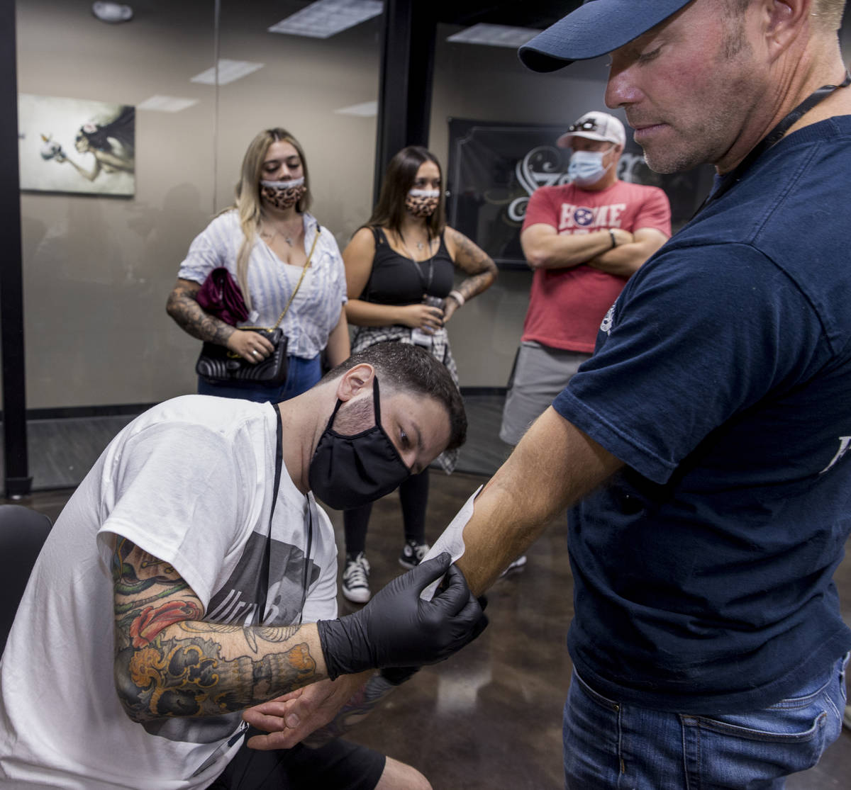 Tattoo artist Jim Sylvia, left, transfers a tattoo sketch onto Dean McAuley  as Route 91 shootin … | Las Vegas Review-Journal