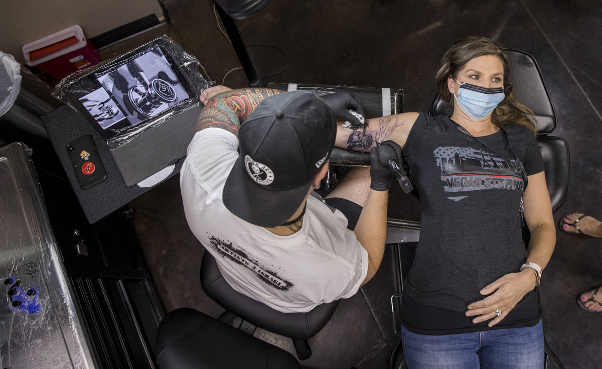Tattoo artist Jeremy Hill, left, works on Rhonda Davis as Route 91 shooting survivors and first ...
