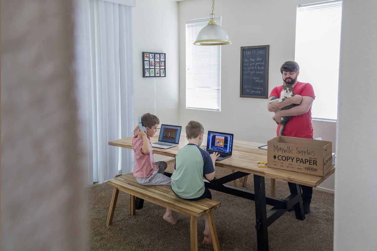 Atticus Mayville, 7, left, and Everett Mayville, 7, work on school projects with help from thei ...