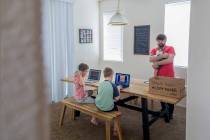 Atticus Mayville, 7, left, and Everett Mayville, 7, work on school projects with help from thei ...