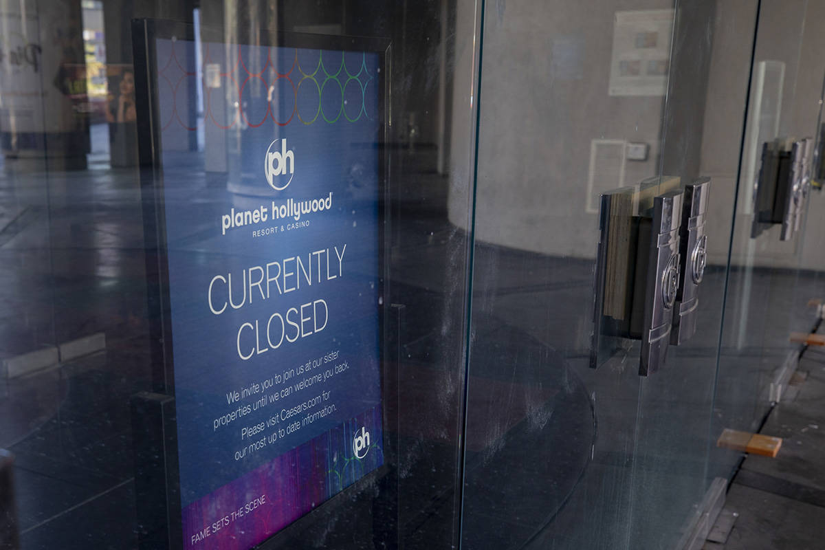 A sign stating Planet HollywoodÕs temporary closure is seen inside the doors of the hotel- ...