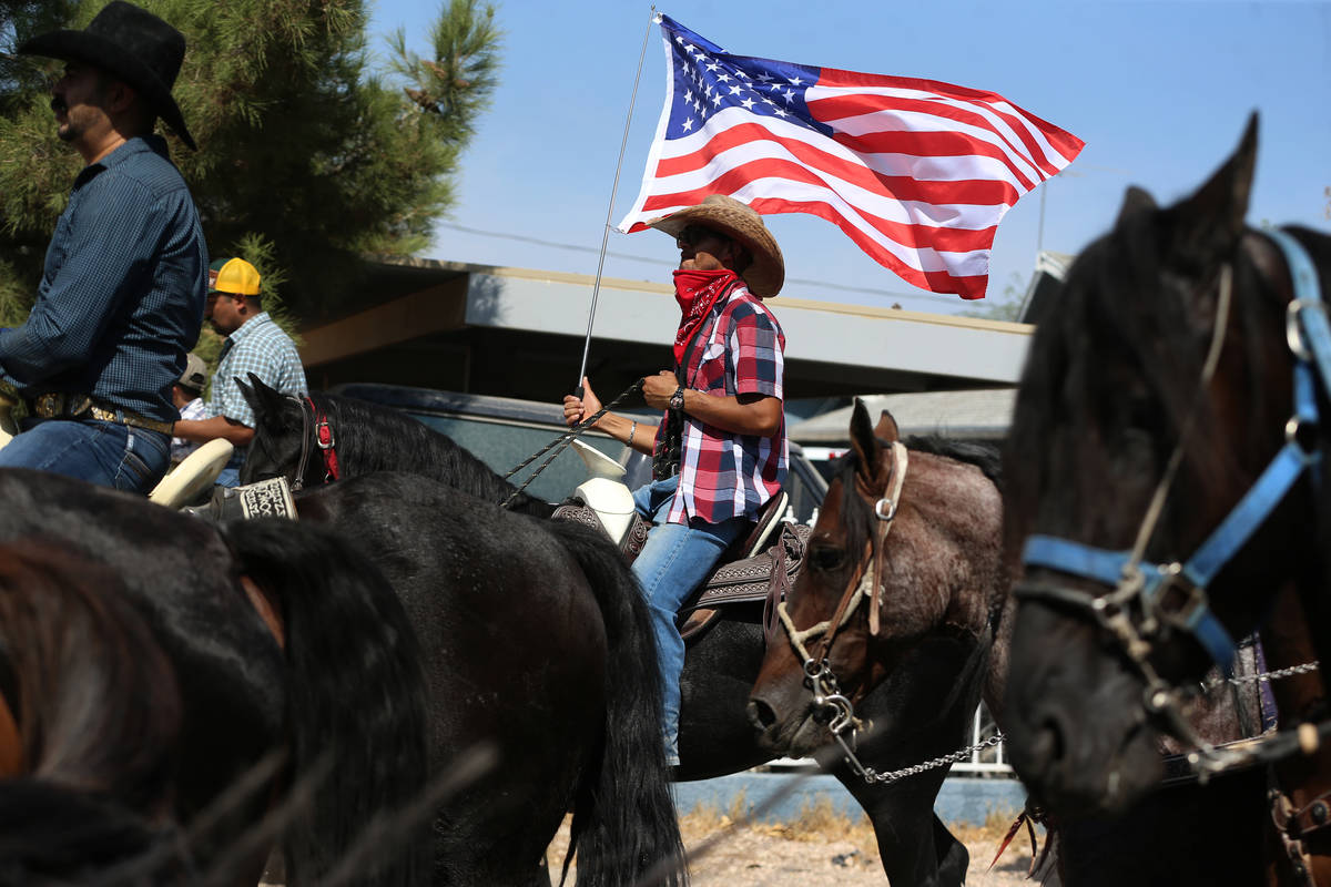 Jose Garcia, center, holds an American flag while participating in a canvassing event for Assem ...