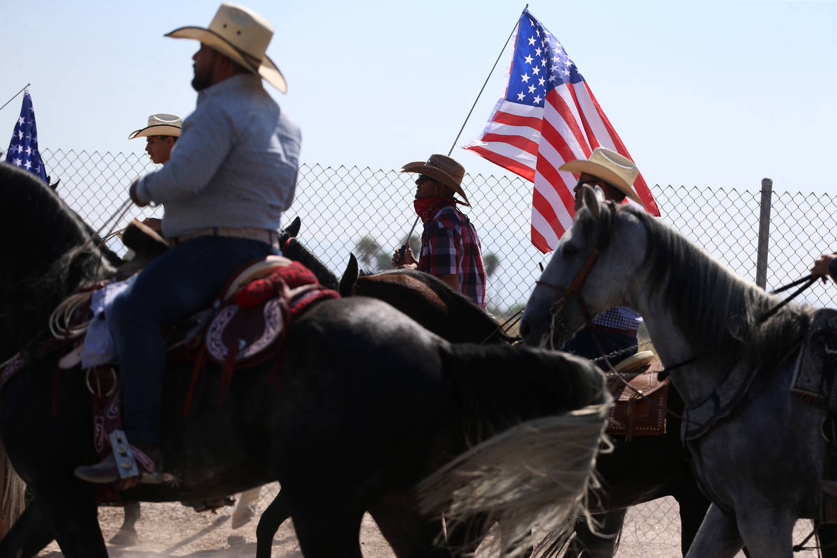 Jose Garcia, center, holds an American flag while participating in a canvassing event for Assem ...