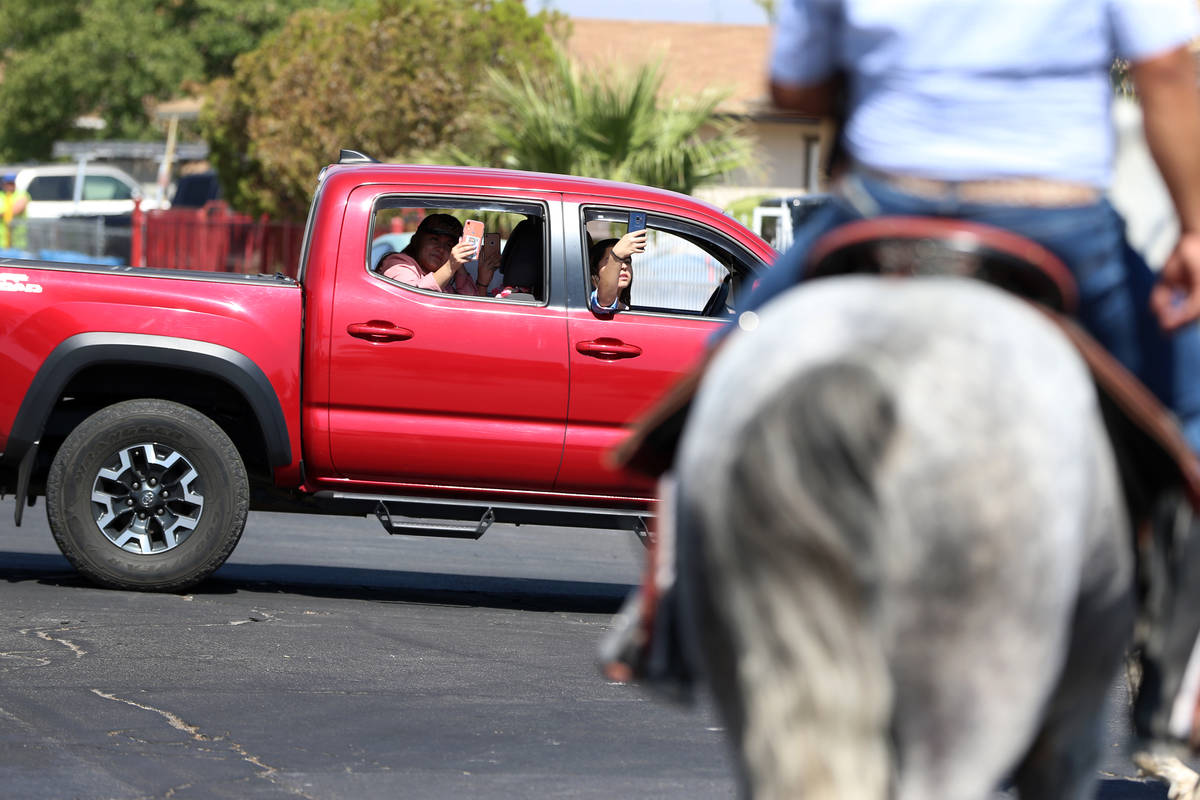 People watch as a caravan of horseback riders take the streets for a canvassing event in suppor ...