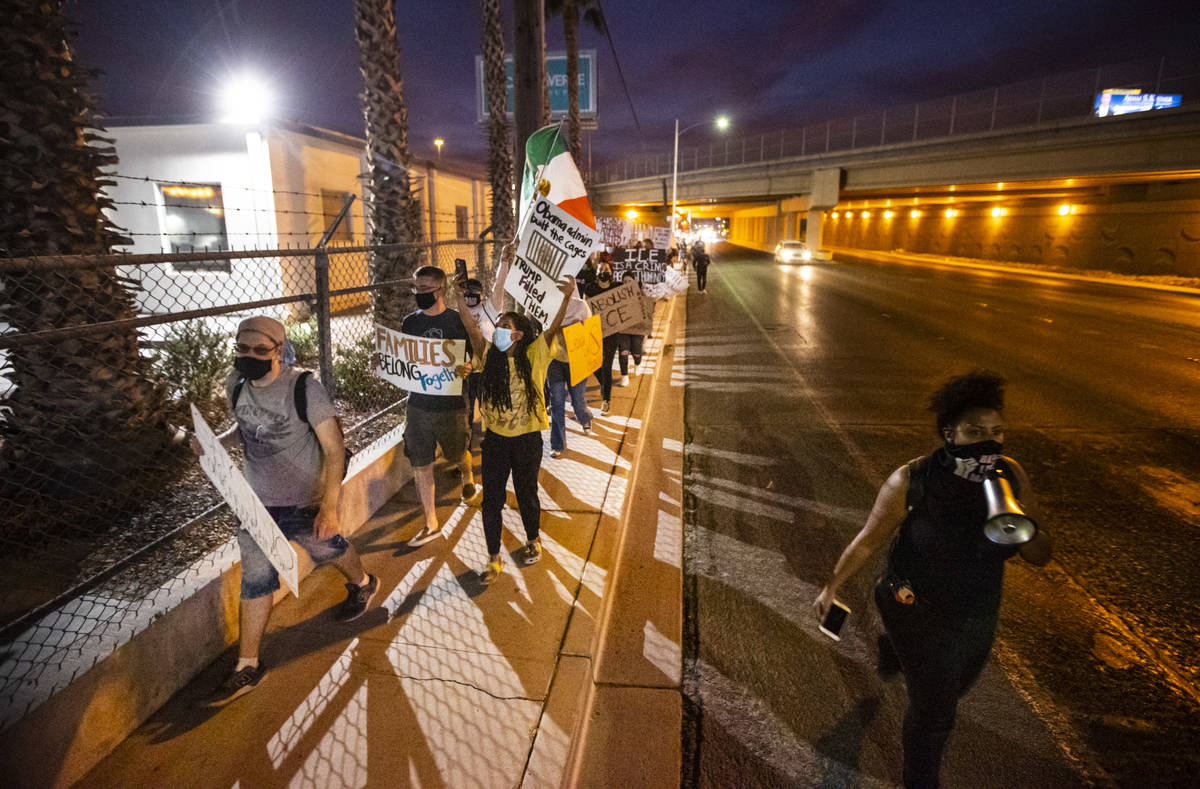 People march down Bonanza Road during a protest against U.S. Immigration and Customs Enforcemen ...