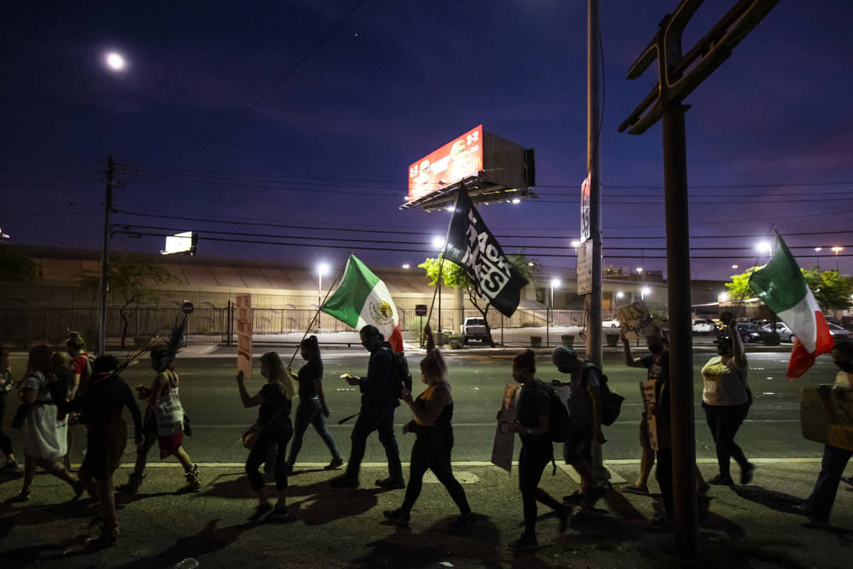 People march down Bonanza Road during a protest against U.S. Immigration and Customs Enforcemen ...