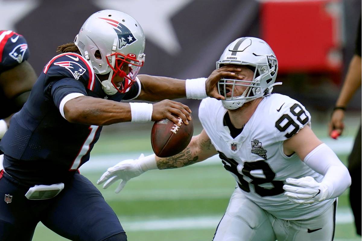 Las Vegas Raiders defensive end Maxx Crosby (98) gets a poke in the eye as he closes in to sack ...