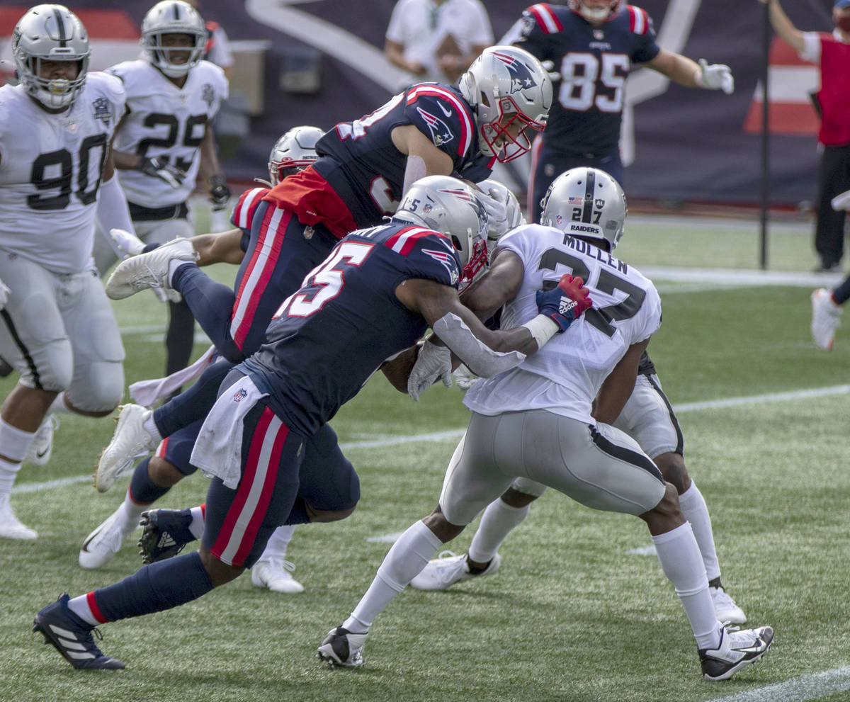 New England Patriots running back Rex Burkhead (34) leaps over Las Vegas Raiders cornerback Tra ...