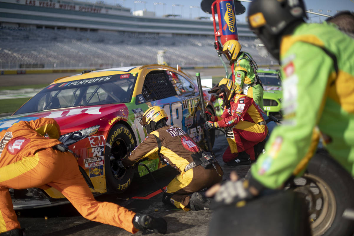 The pit crew for Kyle Busch (18) runs out to service the car during a NASCAR Cup Series au ...